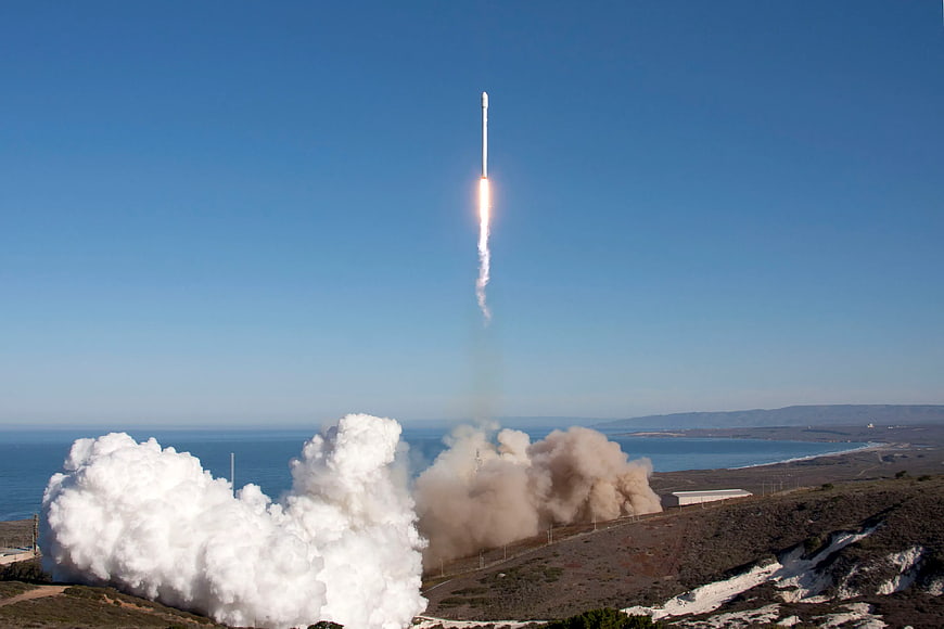 Rocket Launching Vertically into Blue Sky with Smoke Trail