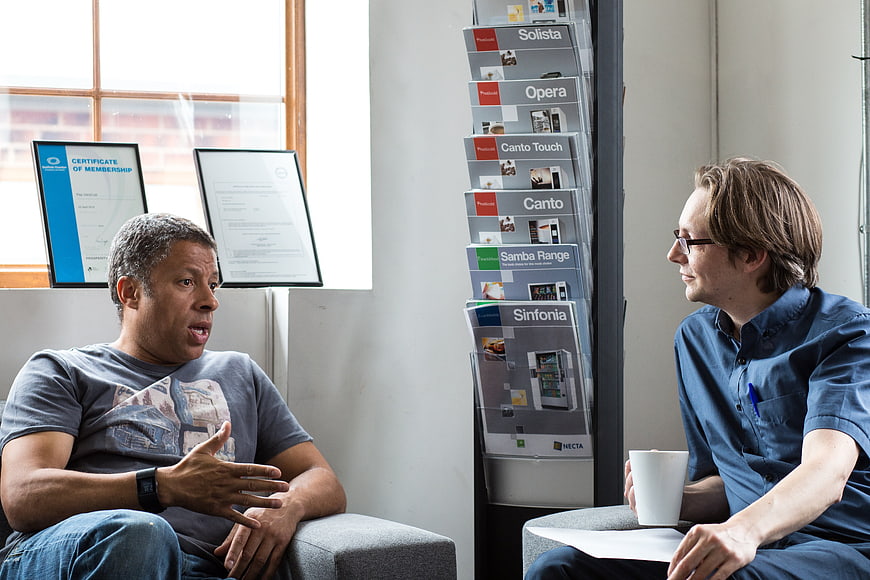 Two men having an informal business discussion in an office