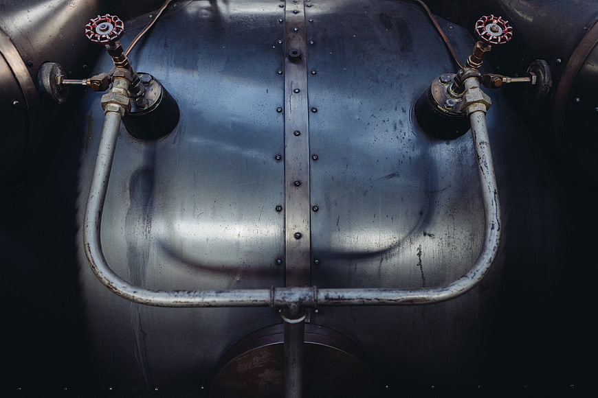 Close-up of vintage industrial metal tank with pipes and valves