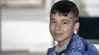 Portrait of a smiling young boy in a blue jacket