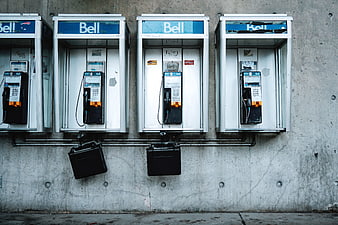 Row of vintage Bell payphones on concrete wall
