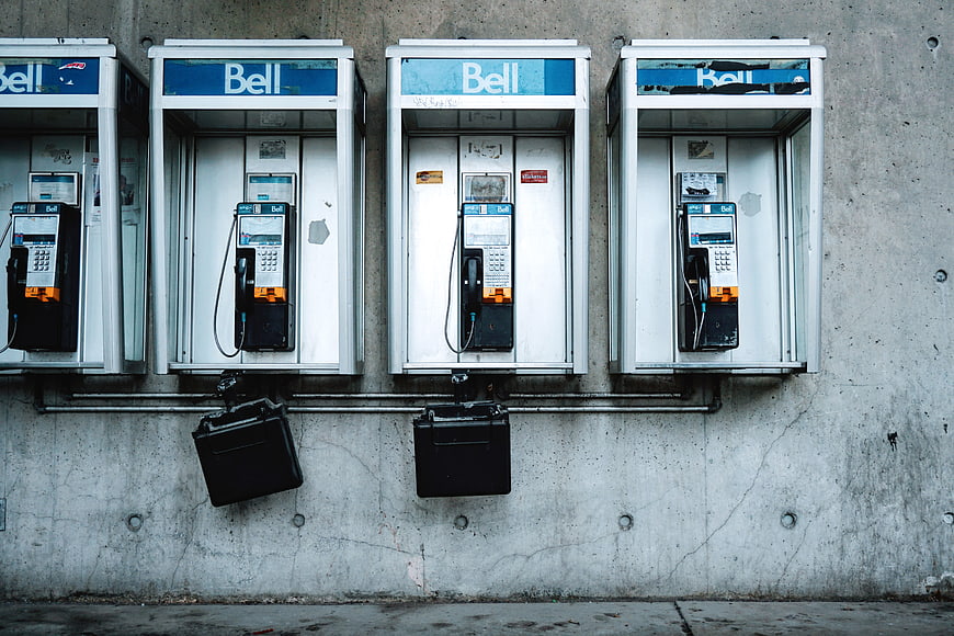 Row of vintage Bell payphones on concrete wall