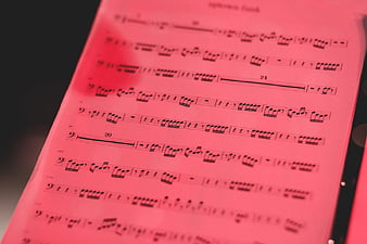 Close-up of sheet music with red lighting and shallow depth of field