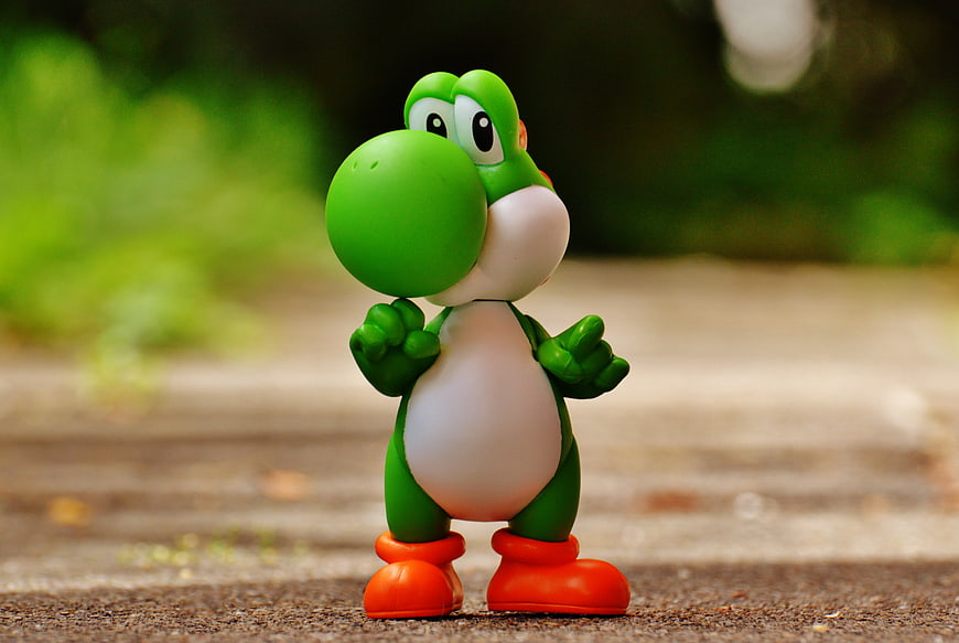 Close-up of Yoshi toy figure standing on pavement