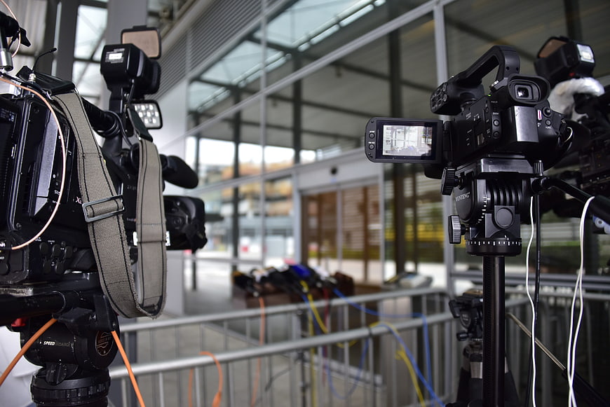 Professional broadcast cameras and media equipment setup in a modern venue