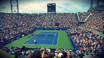 Wide shot of professional tennis match in packed stadium