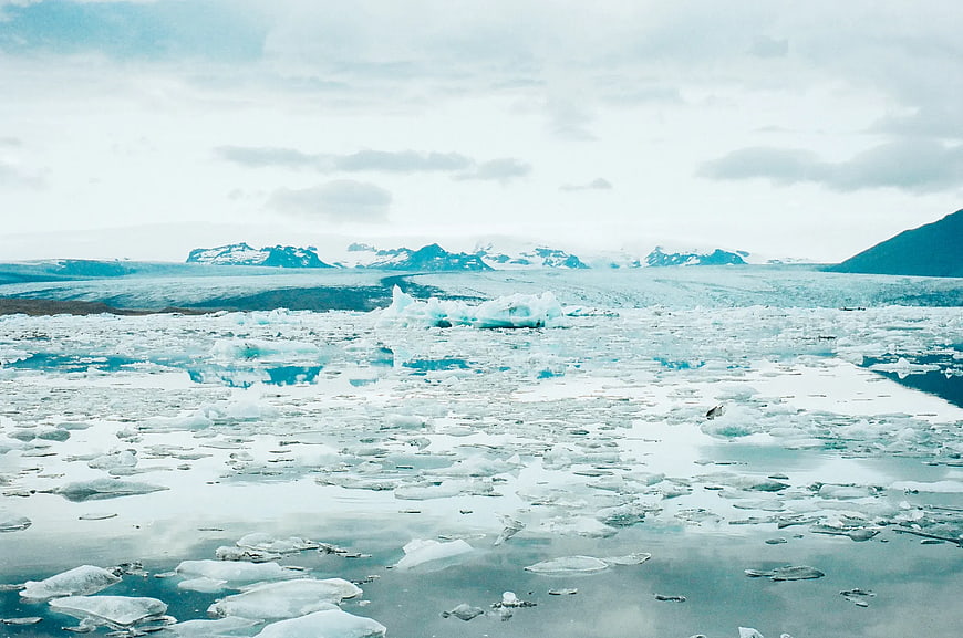 Glacial Lagoon with Floating Icebergs and Mountains
