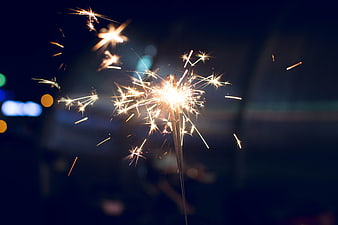Sparkler Burning Brightly Against Dark Night Sky Background