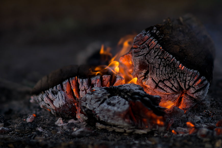 Close-up of burning logs with glowing embers and flames