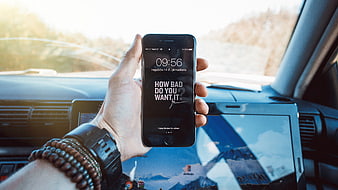 Hand holding smartphone with motivational quote in car