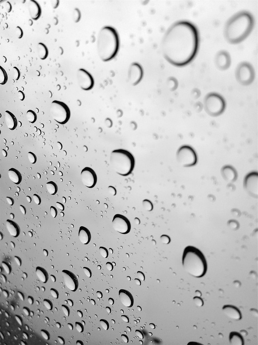 Black and white raindrops on glass window texture