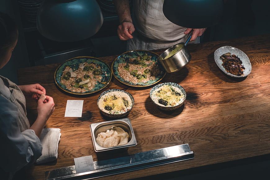 Chefs plating gourmet dishes in a restaurant kitchen