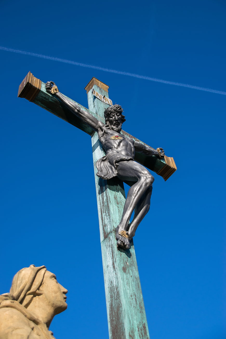 Bronze Crucifixion Statue Against Blue Sky