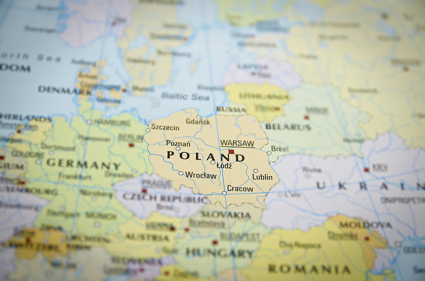 Close-up of a physical map highlighting Poland and Warsaw