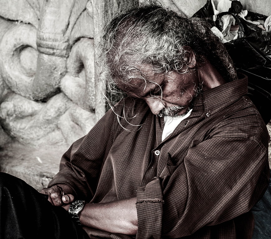 Sleeping elderly homeless man in sepia tone portrait