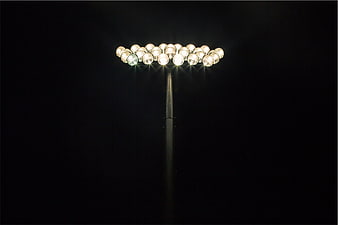 Bright Stadium Floodlights Illuminating Dark Night Sky
