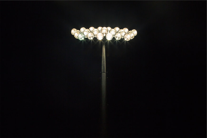 Bright Stadium Floodlights Illuminating Dark Night Sky
