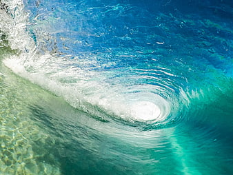 Aerial view of turquoise ocean wave forming a whirlpool