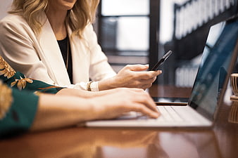 Businesswomen working on laptop and smartphone in office