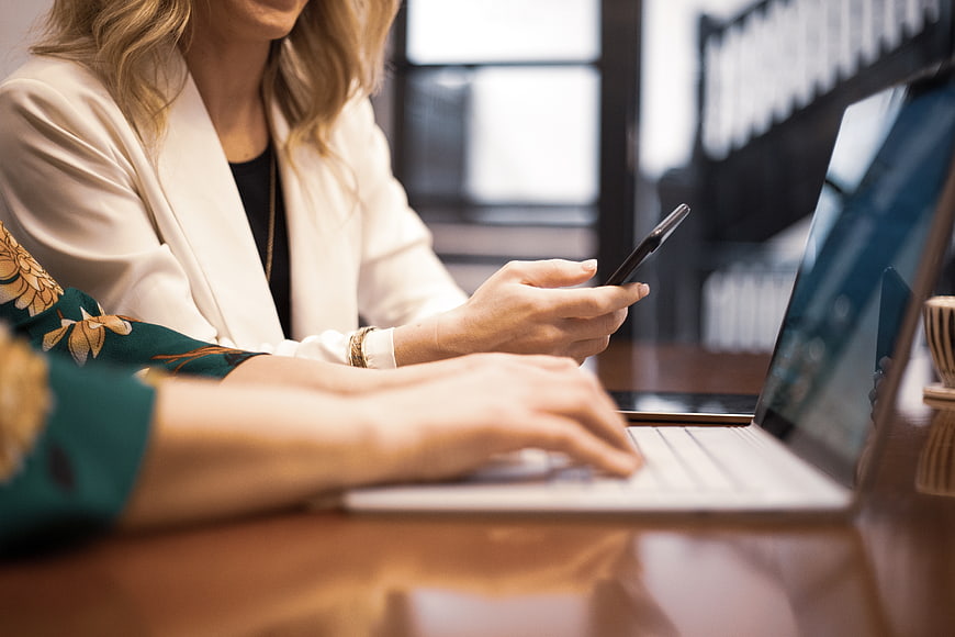 Businesswomen working on laptop and smartphone in office