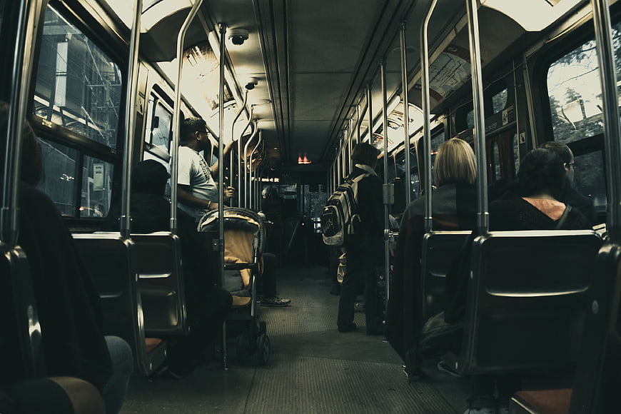 Interior of a crowded commuter train with passengers