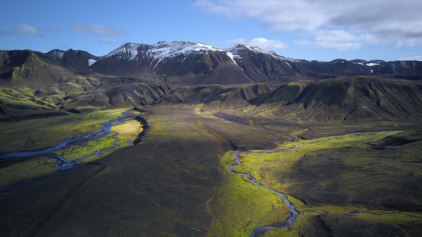 Aerial View of Snow-Capped Mountains and Winding River in Iceland