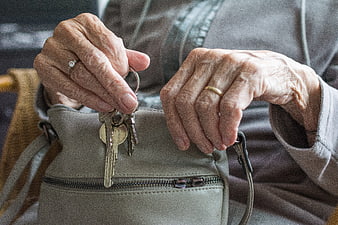 Close-up of elderly woman's hands holding keys and purse