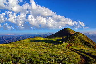 Sunny Green Mountain Ridge with Winding Trail and Blue Sky