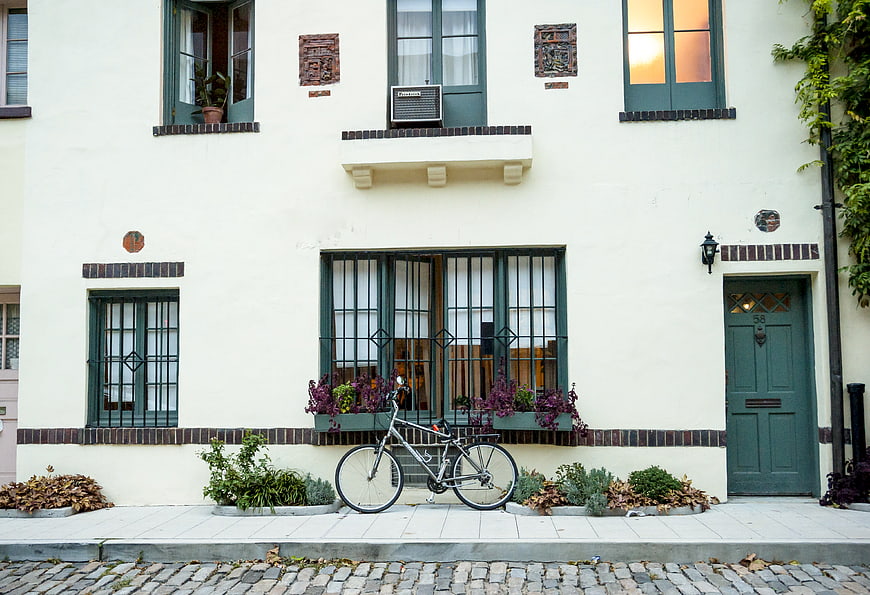 Vintage bicycle parked in front of a cream-colored urban building facade
