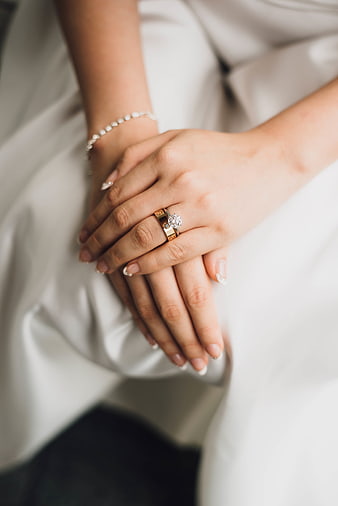 Close-up of bride's hands with diamond engagement ring and wedding band
