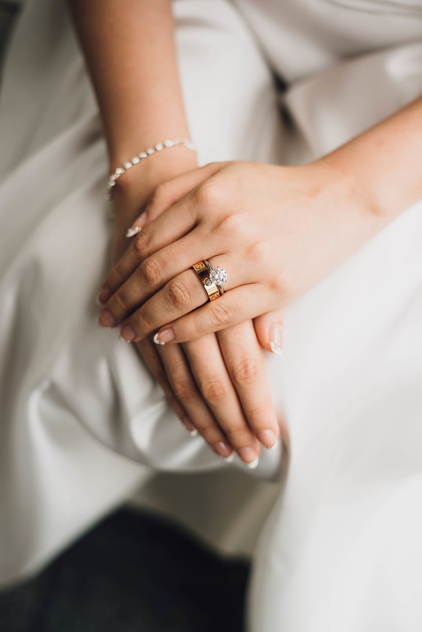 Close-up of bride's hands with diamond engagement ring and wedding band
