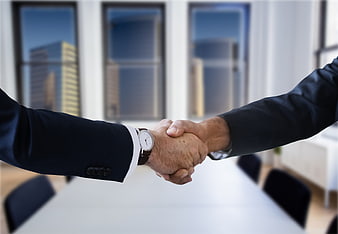 Business handshake in modern office with city view