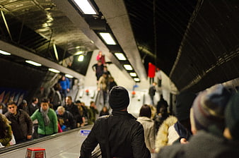 Crowded subway escalator with commuters in winter clothing