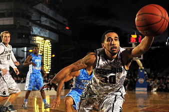 Basketball player in camouflage uniform dribbling during game
