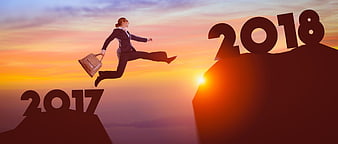 Businesswoman jumping from 2017 to 2018 at sunset
