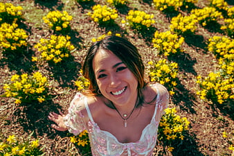 Smiling Woman in Floral Dress in Yellow Flower Field