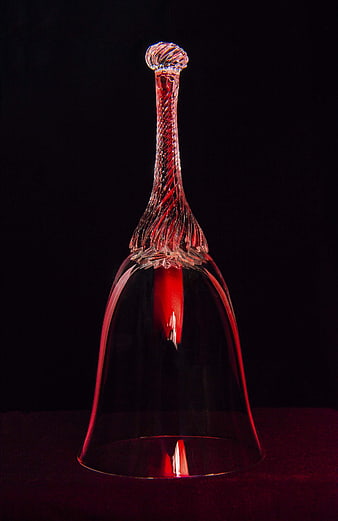Upside down red crystal wine glass on black background