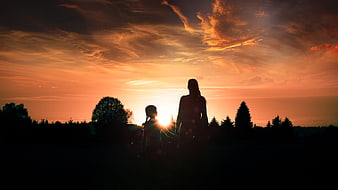 Silhouette of Mother and Child Walking at Sunset