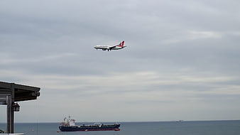 Turkish Airlines plane landing over cargo ship at sea