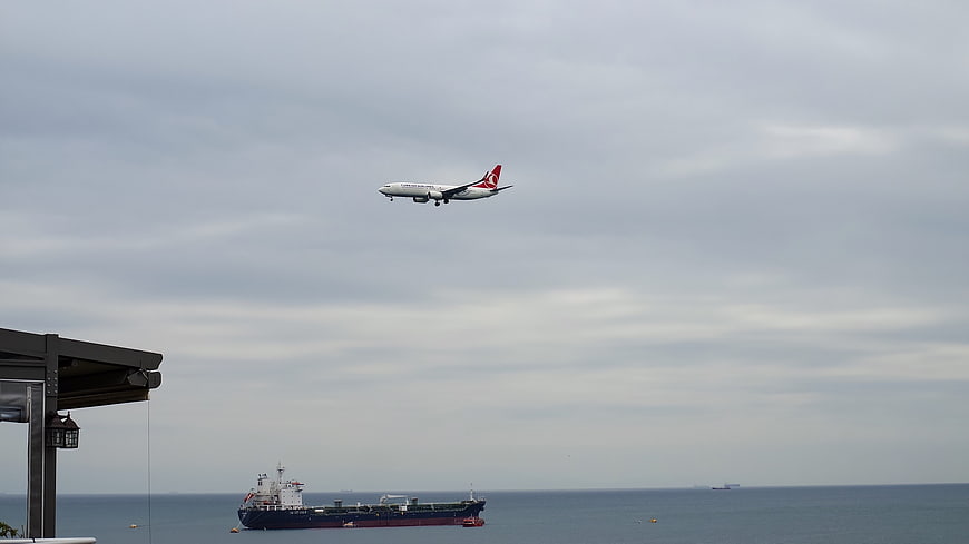 Turkish Airlines plane landing over cargo ship at sea