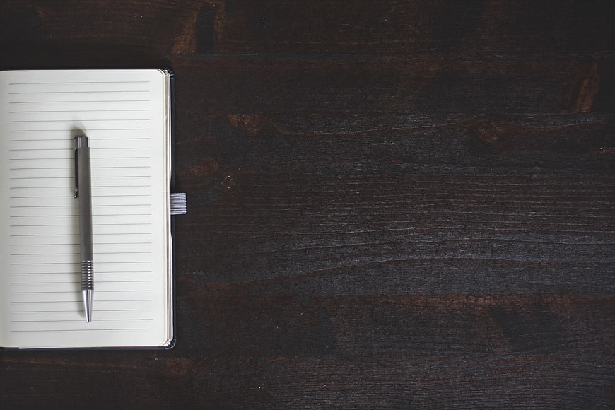 Open Notebook and Pen on Dark Wood Background