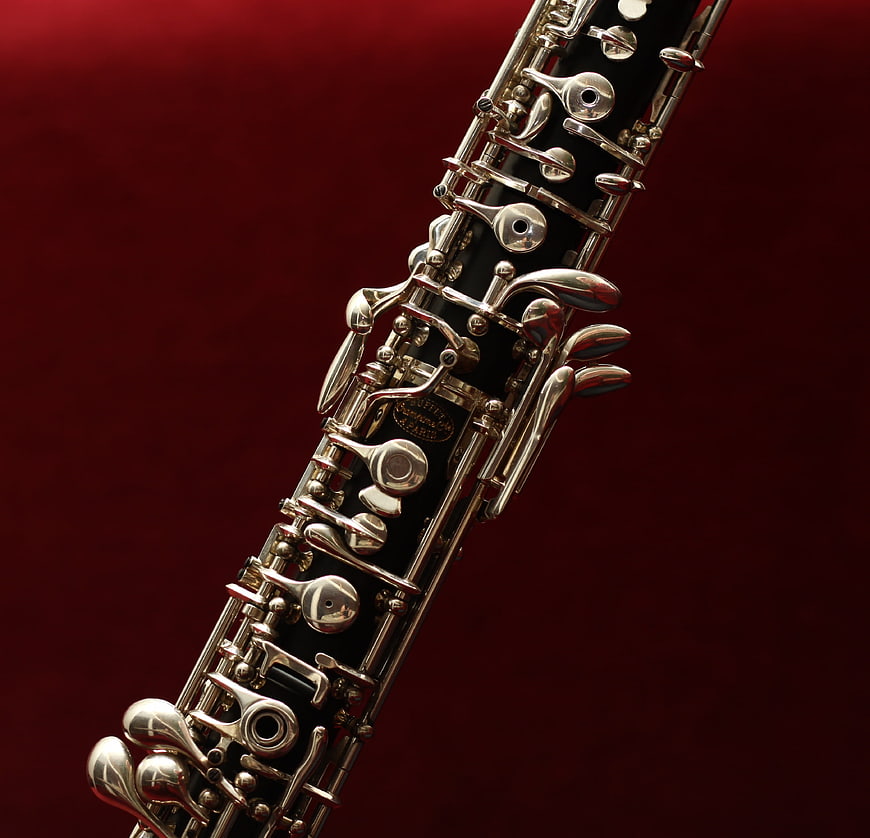Close-up of silver oboe keys on deep red background