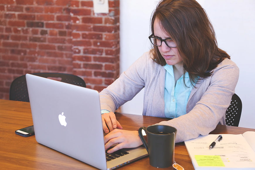 Woman working on laptop in modern office workspace
