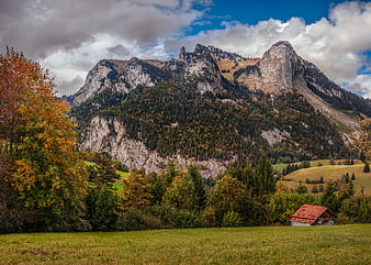 Autumn mountain landscape with rustic cabin and colorful trees