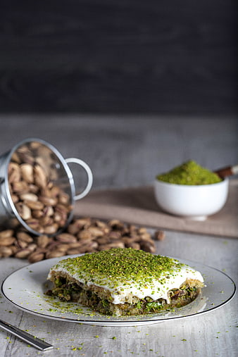 Traditional Pistachio Baklava with Spilled Nuts on Rustic Table