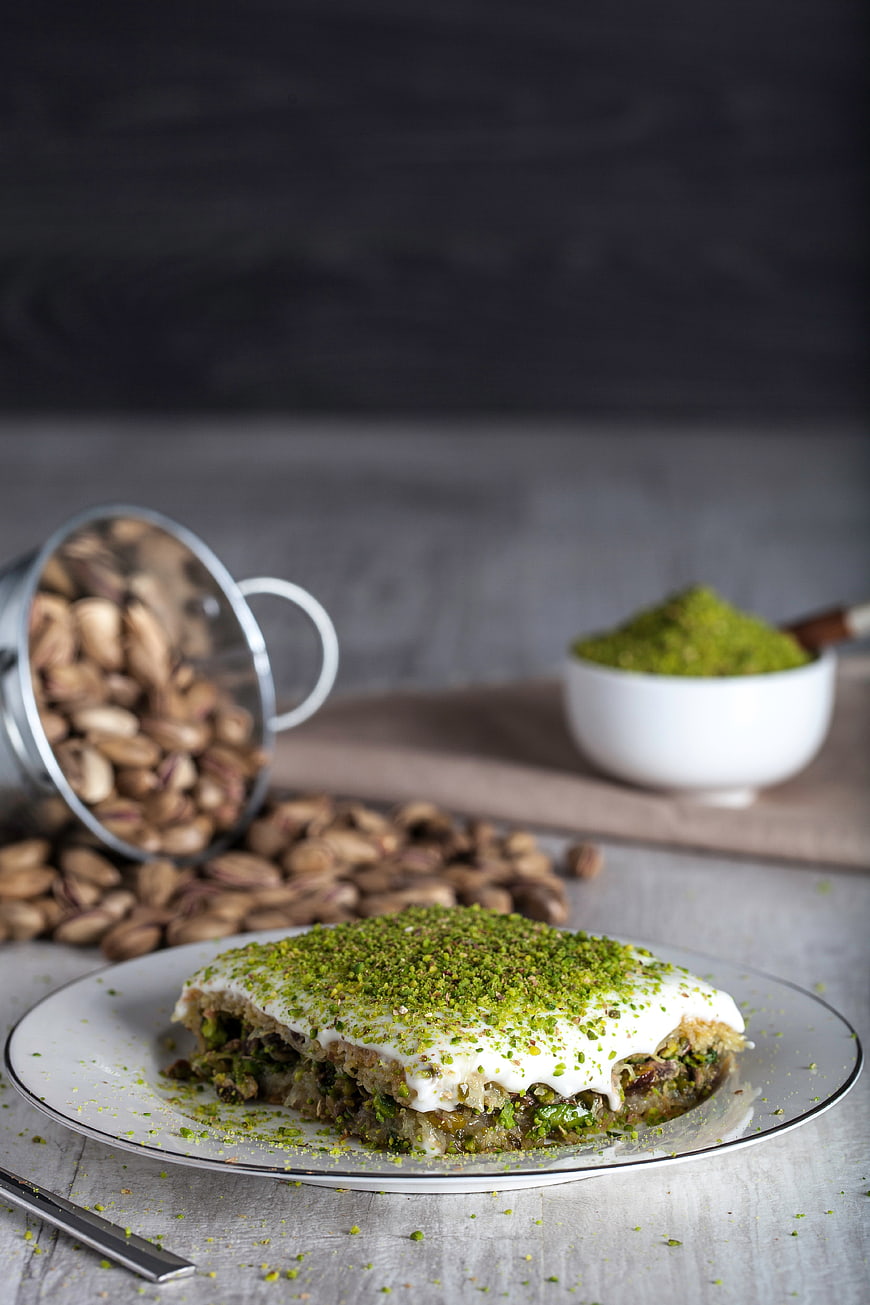 Traditional Pistachio Baklava with Spilled Nuts on Rustic Table