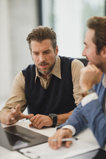 Two businessmen discussing strategy in a modern office meeting