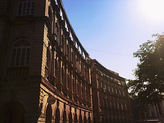 Low angle view of historic curved architecture against blue sky