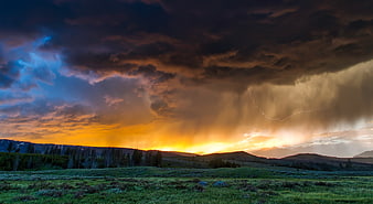 Dramatic Lightning Storm Over Mountain Meadow at Sunset