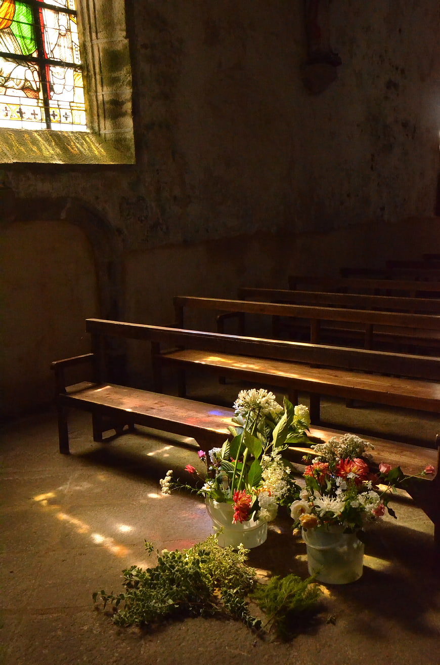 Flowers on Stone Floor in Dimly Lit Chapel Interior